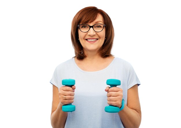 Foto glimlachende oudere vrouw met dumbbells die oefent