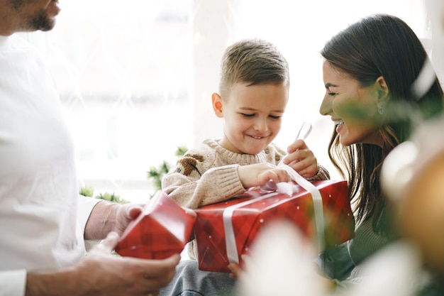 Glimlachende ouders die kerstcadeau geven aan zoon thuis