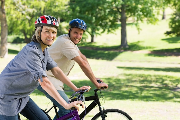 Glimlachende paar berijdende fietsen in park