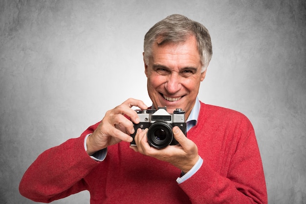 Glimlachende rijpe mens die een uitstekende camera houdt