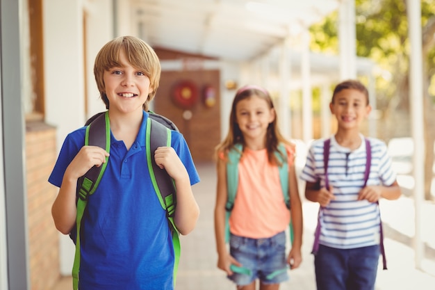 Glimlachende schooljonge geitjes die zich in schoolgang bevinden