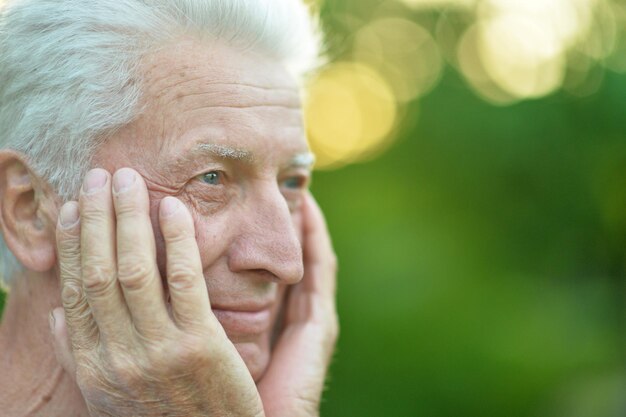 Glimlachende senior man poseren in zomer park