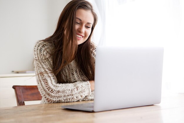 glimlachende student die naar een laptop kijkt