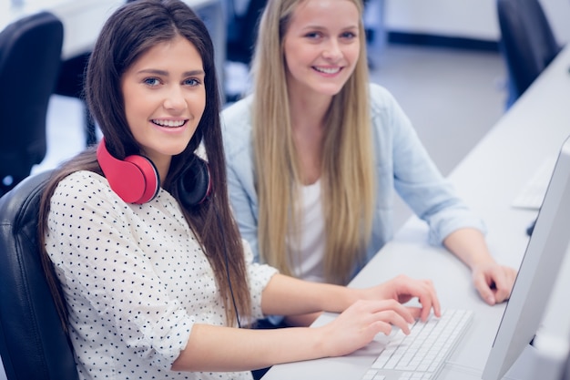 Glimlachende studenten die computer met behulp van bij universiteit