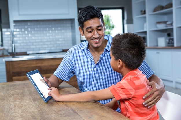 Glimlachende vader die tablet met zijn zoon gebruikt