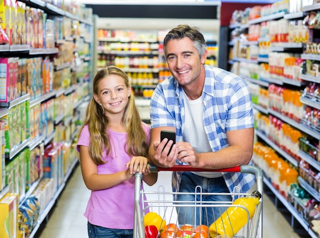 Glimlachende vader en dochter in de supermarkt