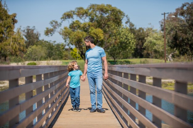 Glimlachende vader en zoon wandelen buiten familie waarde jeugd en ouderschap