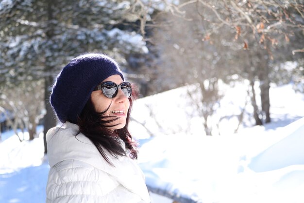 Glimlachende volwassen vrouw met warme kleding in de winter