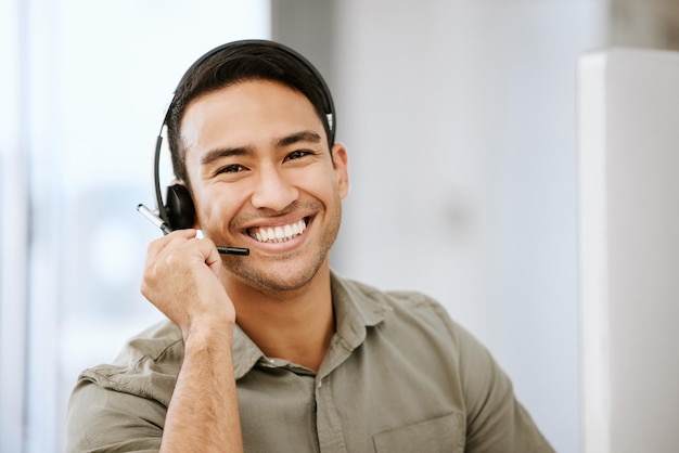 Glimlachende vriendelijke callcenteragent met headset voor online advies in een IT-techbureau Gezicht van mannelijke e-commerceondersteuningsprofessional die virtuele hulp biedt aan webgebruiker of neem contact met ons op hotline