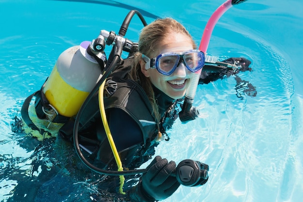 Foto glimlachende vrouw bij scuba-uitrusting de opleiding in zwembad