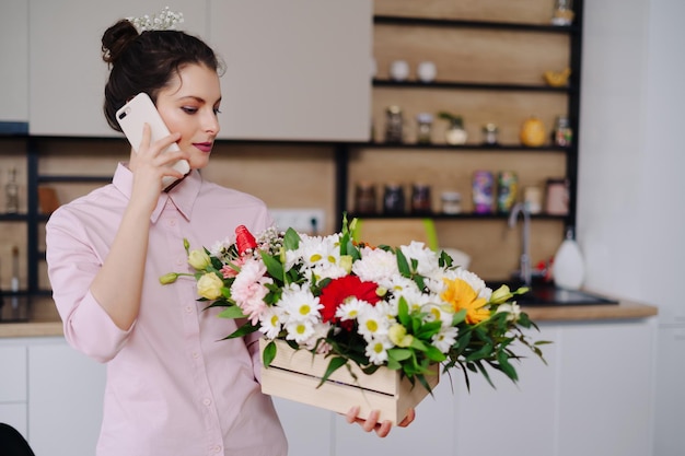 Glimlachende vrouw Bloemist Klein bedrijf Eigenaar bloemenwinkel Ze gebruikt haar telefoon en laptop om bestellingen op te nemen voor haar online winkel Thuiswerken