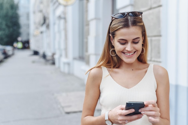 Glimlachende vrouw communiceert via haar telefoonmeisje e-learning via haar gadget