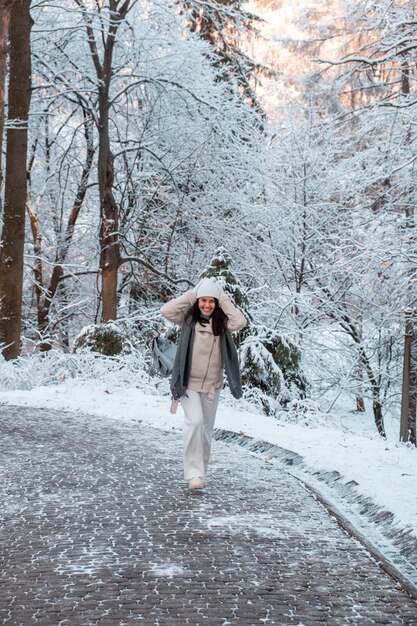 Glimlachende vrouw die door de kopieerruimte van het winterpark loopt