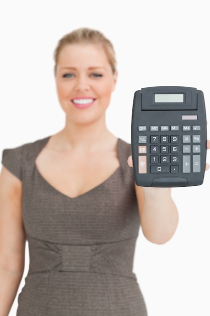 Foto glimlachende vrouw die een calculator toont