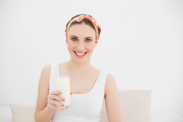 Glimlachende vrouw die een glas melk houdt