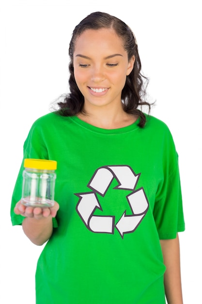 Glimlachende vrouw die groene de holdingskruik van de recyclingst-shirt draagt