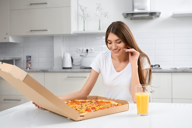 Glimlachende vrouw die grote smakelijke pizza houdt