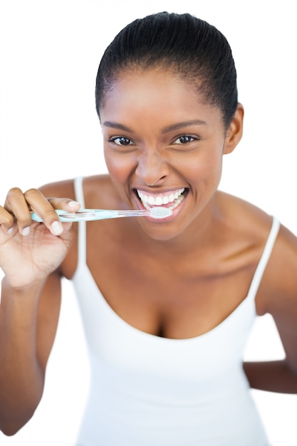 Glimlachende vrouw die haar tanden borstelt