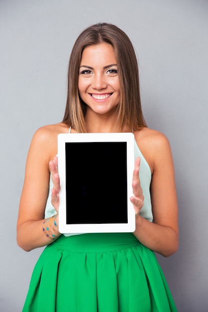 Glimlachende vrouw die het scherm van de tabletcomputer toont