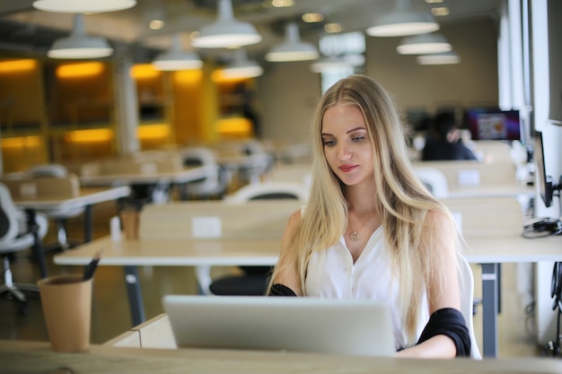 Glimlachende vrouw die laptop op de werkplek gebruikt voor kleine bedrijven die het publiek willen betrekken en het creëren van inhoud willen schalen, kunnen nieuwe marketingtechnologie in de werkruimte toepassen. Freelancer-concept.