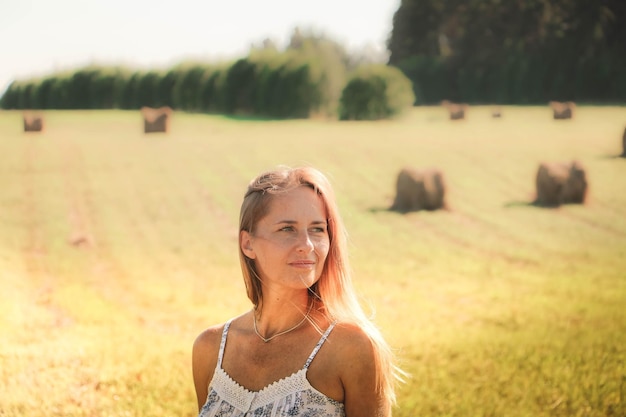 Glimlachende vrouw die op een boerderij staat tijdens een zonnige dag