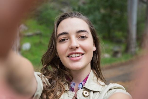 Glimlachende vrouw die selfies neemt