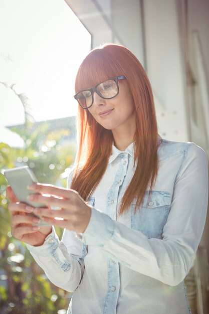 Glimlachende vrouw die smartphone gebruikt