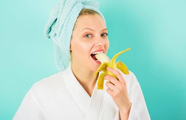 Glimlachende vrouw eet banaan. gelukkig meisje op dieet ontbijten. gezonde levensstijl.