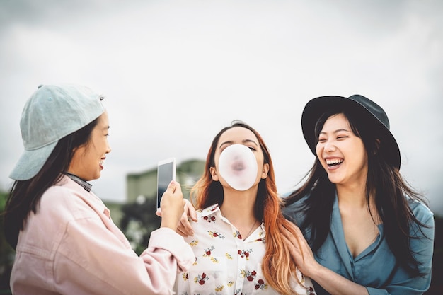 Glimlachende vrouw fotografeert vriend die bubbels blaast