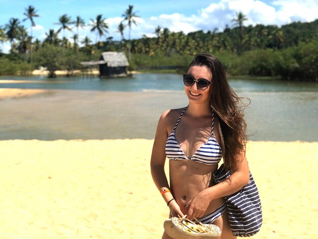 Foto glimlachende vrouw in bikini op het strand.