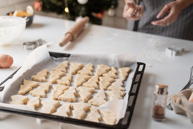 Glimlachende vrouw in de keuken die kerstkoekjes bakt