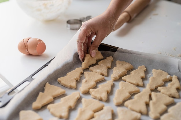 Glimlachende vrouw in de keuken die kerstkoekjes bakt