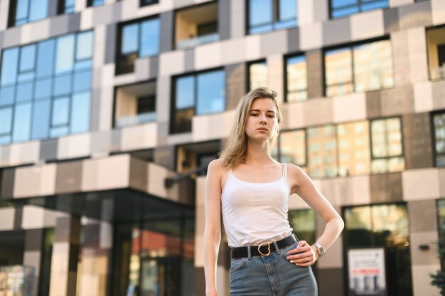 Glimlachende vrouw in een wit T-shirt en spijkerbroek