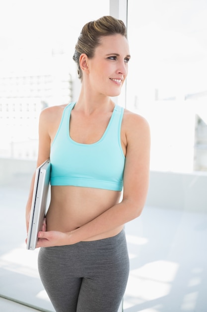 Glimlachende vrouw in laptop van de sportkledingsholding