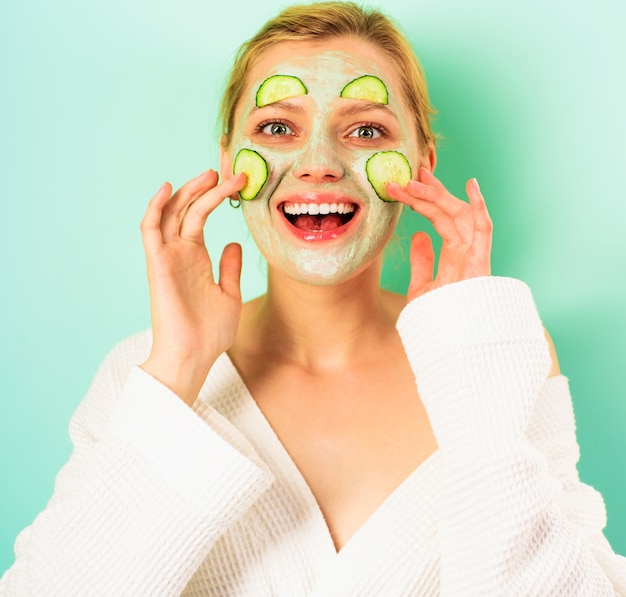 Glimlachende vrouw met cosmetisch masker op gezicht. Gelukkig meisje met gezichtsmasker. Schoonheidsbehandeling. Spa therapie. Cosmetische ingrepen.