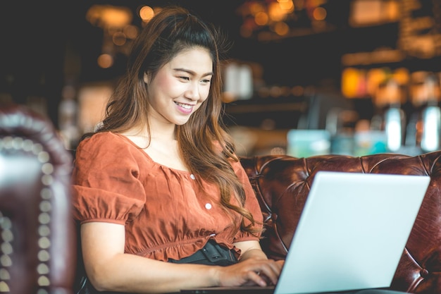 Glimlachende vrouw met een laptop in een café