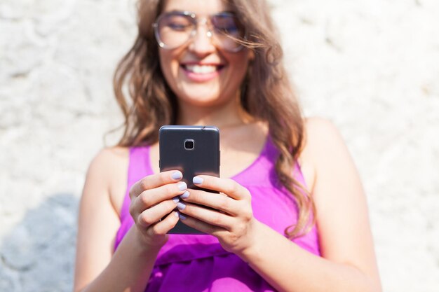 Foto glimlachende vrouw met een mobiele telefoon op een zonnige dag