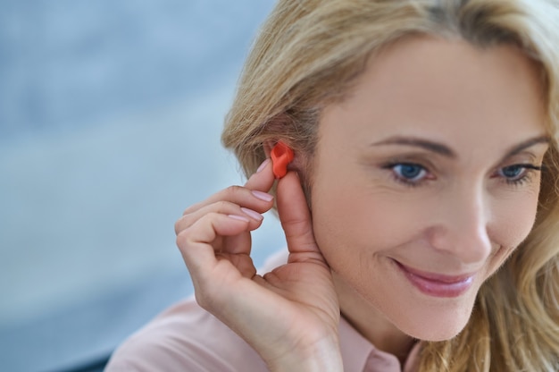 Foto glimlachende vrouw met gehoorapparaat dichtbij oor