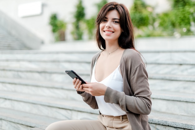 Glimlachende vrouw met mobiele telefoon