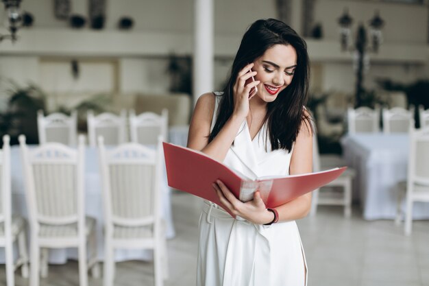 Glimlachende vrouw met omslag die op telefoon spreken