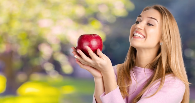 Glimlachende vrouw met rode appel