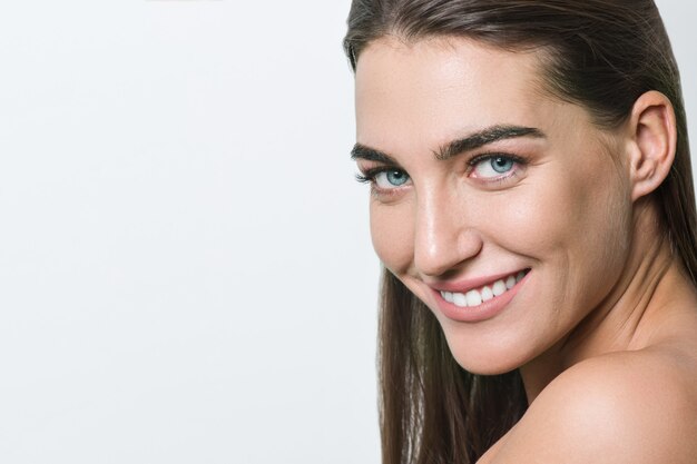 Glimlachende vrouw met schone huid, natuurlijke make-up