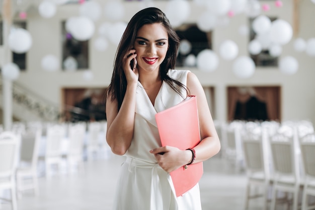 Glimlachende vrouw met telefoon en omslag