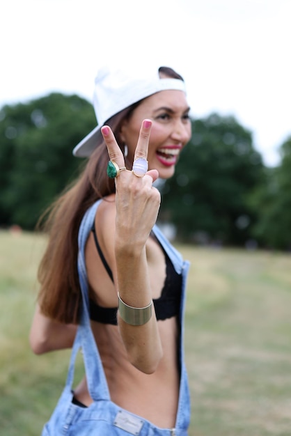 Foto glimlachende vrouw toont een vredesteken terwijl ze op het veld staat