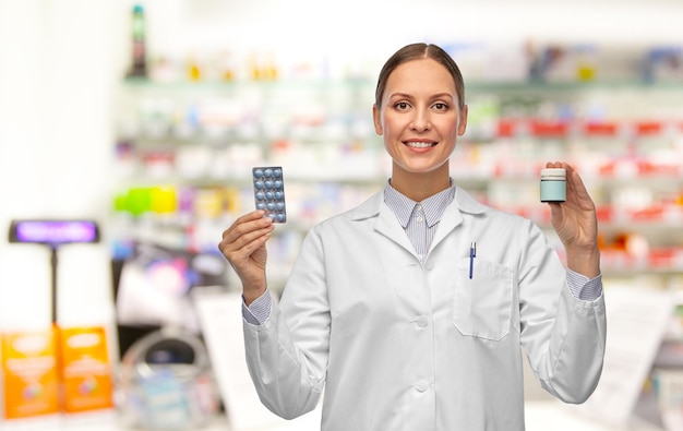 glimlachende vrouwelijke arts met medicijnen in de apotheek