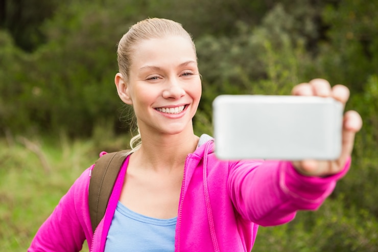 Foto glimlachende vrouwelijke wandelaar die een selfie nemen