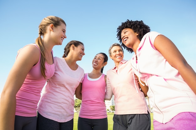 Foto glimlachende vrouwen die roze voor borstkanker dragen
