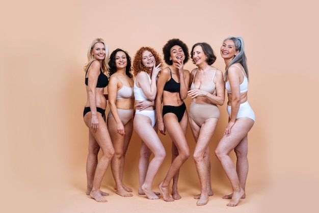 Glimlachende vrouwen in lingerie tegen een gekleurde achtergrond