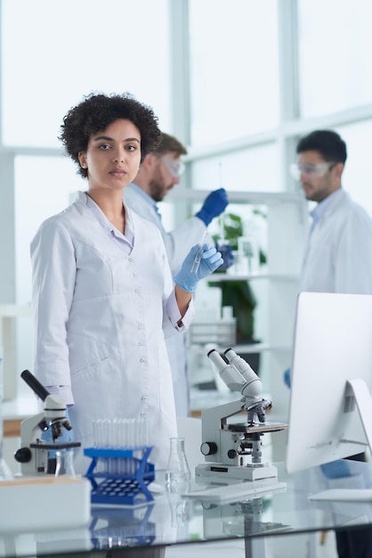 Glimlachende wetenschappers kijken naar cameraarmen gekruist in laboratorium