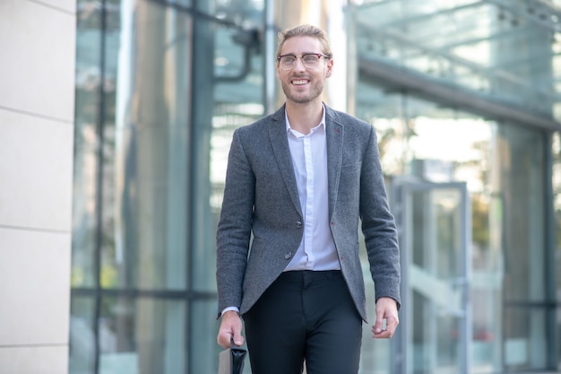 Glimlachende zakenman buiten het gebouw